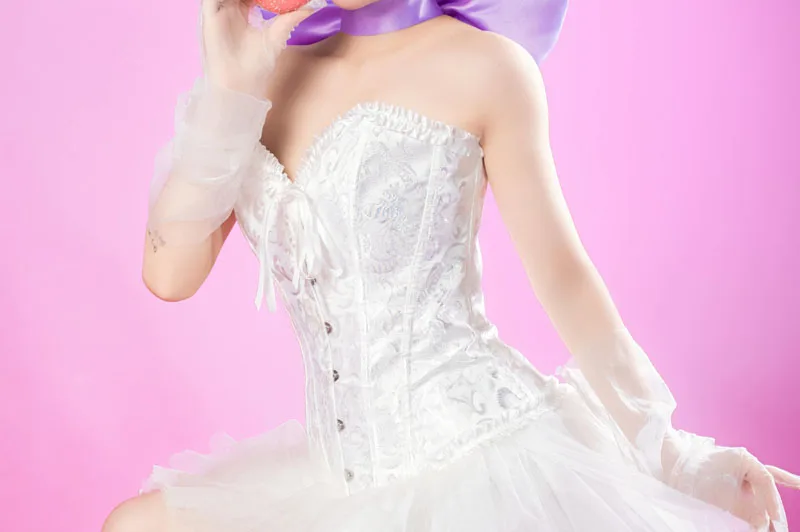 Femme en corset brodé blanc et jupon assorti, portant des gants transparents blancs et un ruban violet au cou.